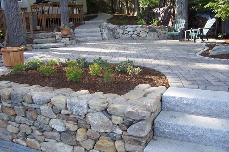 Paver patio with stacked stone wall and granite steps