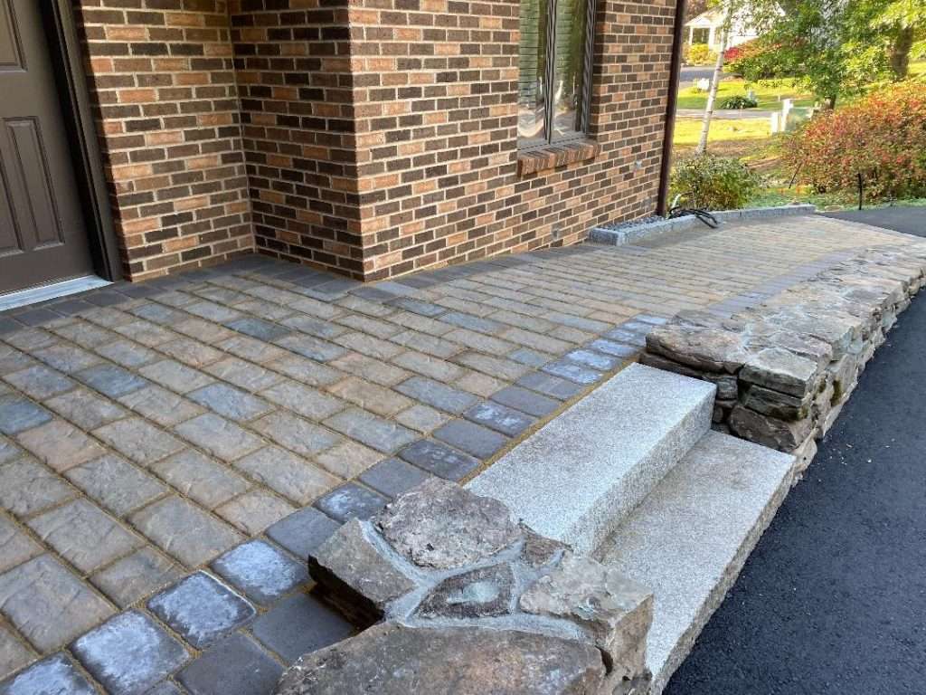 Completed stone ramp entry, granite steps, and professional landscape installation for a New Hampshire home by Landscapes by Tom