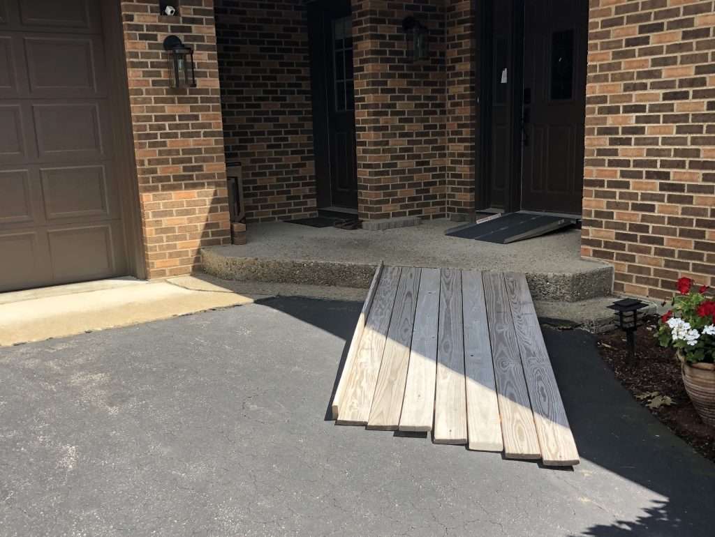 Before photo of a residential entry area prior to stone ramp, walkway, and granite step installation by Landscapes by Tom in New Hampshire