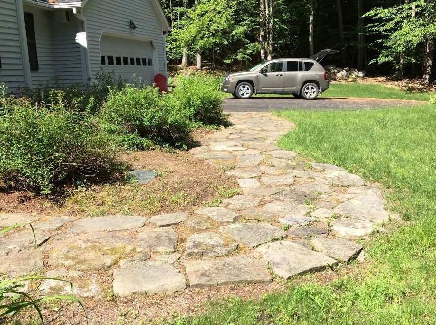 Before photo of a residential front entry walkway prior to natural stone and landscape installation by Landscapes by Tom in New Hampshire