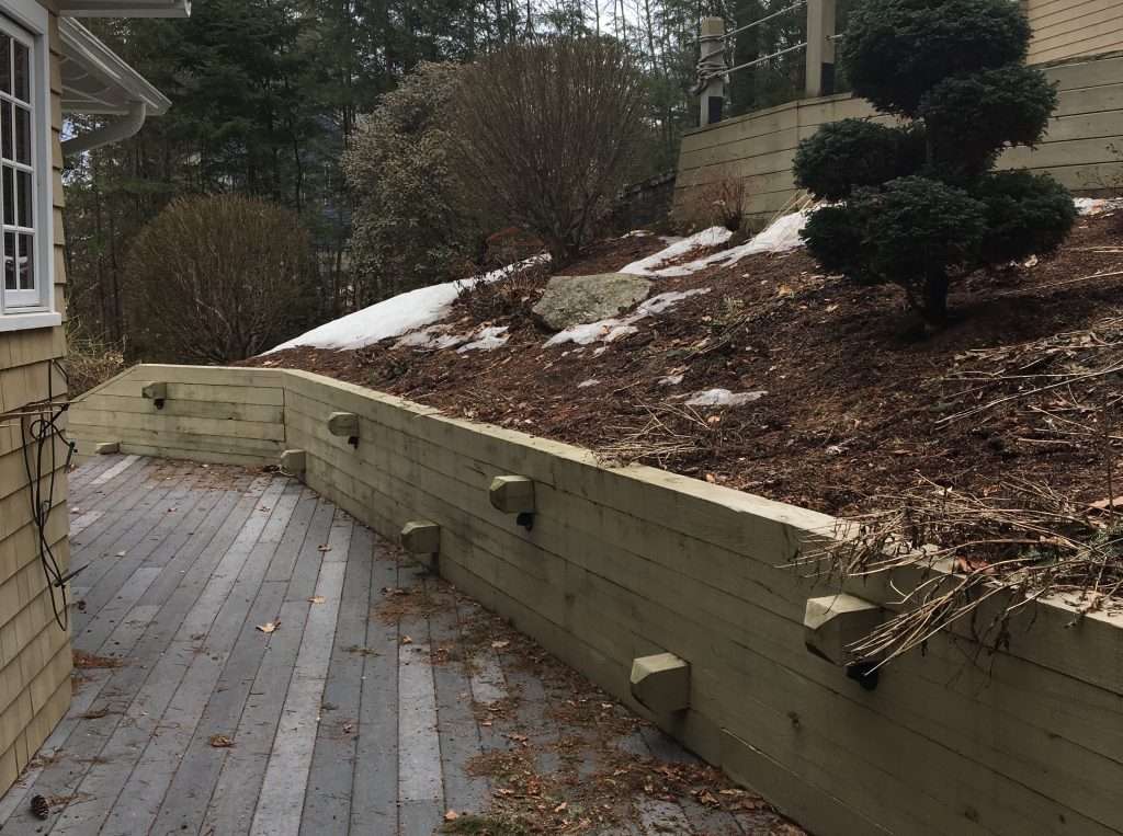 Before photo of a residential landscape area prior to retaining wall, paver patio, and planting installation by Landscapes by Tom in New Hampshire