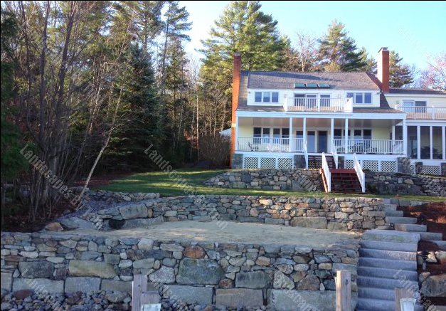Lakeside natural stone retaining walls with custom granite staircase, shoreline hardscaping, terraced landscape construction, and waterfront outdoor living improvements for a New Hampshire lakefront property
