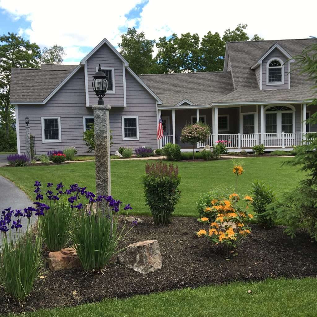 new entry path with granite post and light and mulch bed with plantings