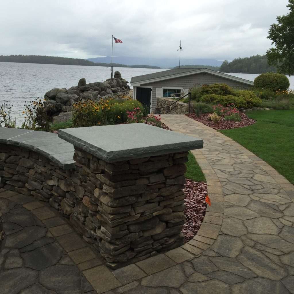 Guide to choosing landscaping materials featuring natural stone, pavers, granite, retaining wall options, mulch, and hardscape design inspiration for New Hampshire outdoor living projects by Landscapes by Tom