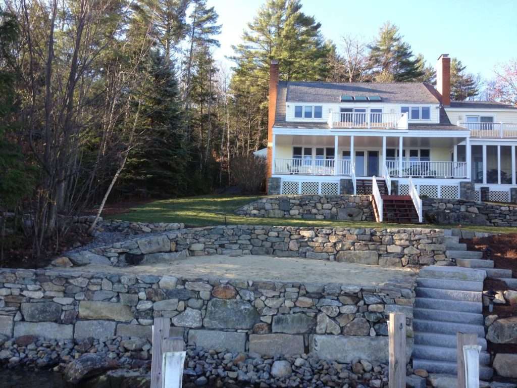 Waterfront Retaining Walls 2 Retaining wall landscaping project featuring natural stone wall construction, erosion control solutions, terraced garden design, drainage improvements, and custom hardscape installation for a New Hampshire property by Landscapes by Tom